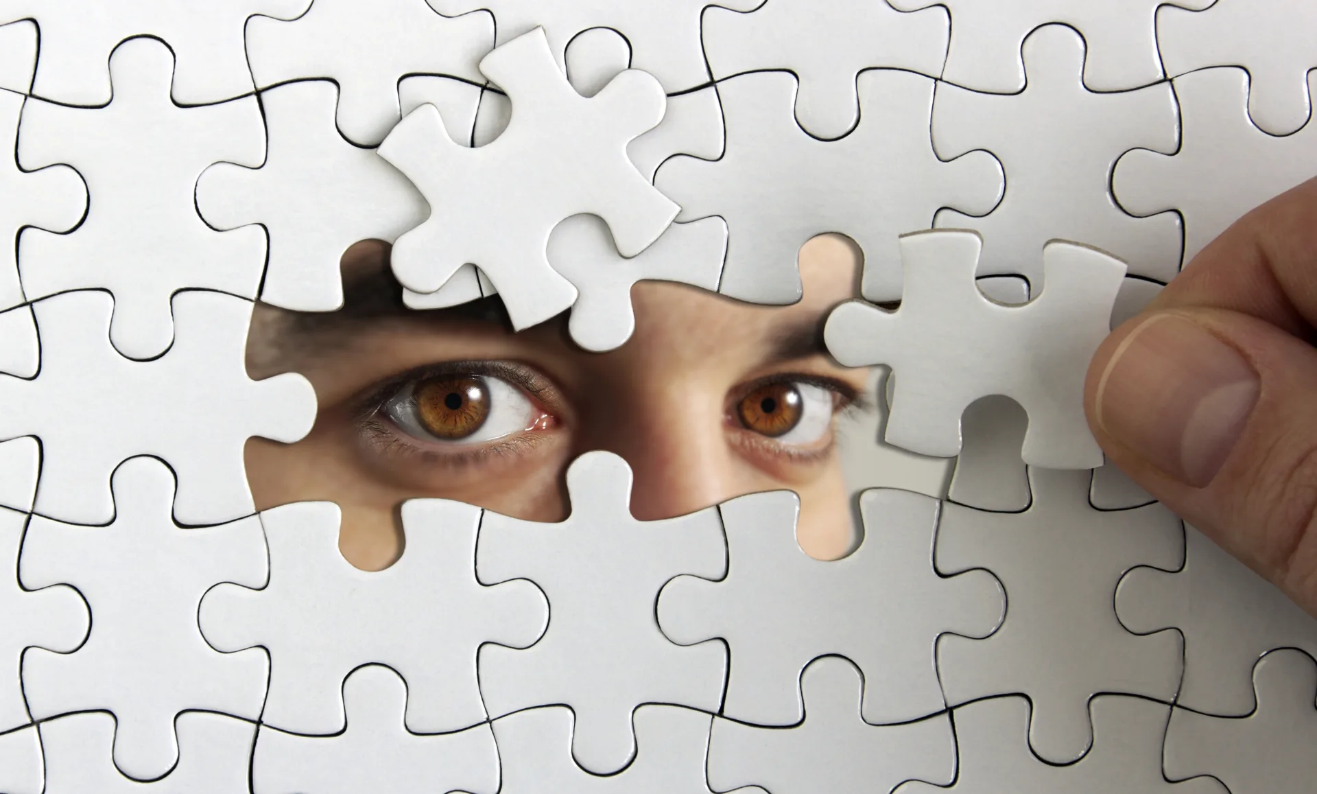 Augen hinter zusammengesetzten Puzzleteilen